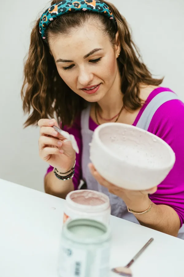 Magda szkliwi ceramiczną miskę